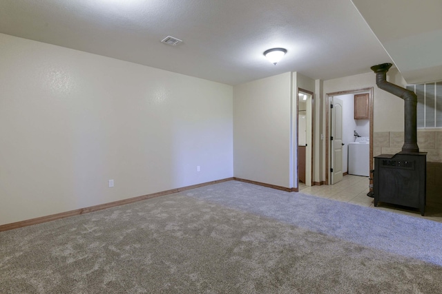 18054 State Highway 39, Aurora, MO 65605 - unfurnished living room with a wood stove, light colored carpet, and washer / clothes dryer