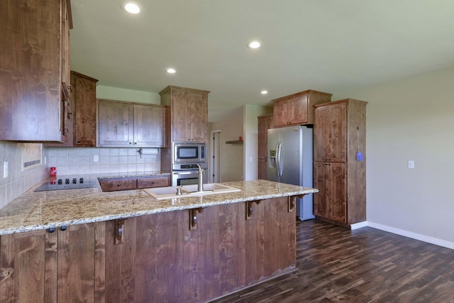 18054 State Highway 39, Aurora, MO 65605 - kitchen with stainless steel appliances, a peninsula, dark wood finished floors, tasteful backsplash, and recessed lighting