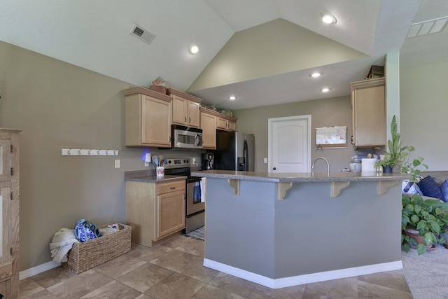 105 Deer Run, Willard, MO 65781 - kitchen featuring stainless steel appliances, a peninsula, a kitchen breakfast bar, lofted ceiling, and light brown cabinets