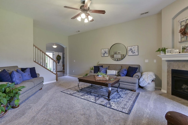 105 Deer Run, Willard, MO 65781 - living area featuring carpet flooring, stairway, a ceiling fan, a fireplace, and arched walkways