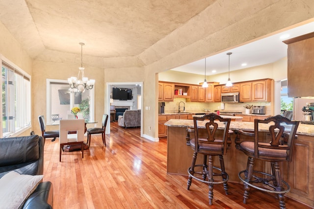 3702 E Dartmoor Ct, Springfield, MO 65802 - kitchen featuring stainless steel microwave, light wood finished floors, light stone countertops, open shelves, and a chandelier