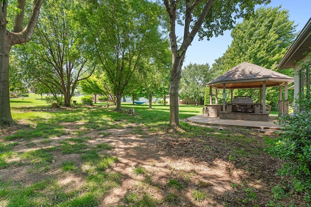 3702 E Dartmoor Ct, Springfield, MO 65802 - view of green lawn with a gazebo, an outdoor stone fireplace, and a patio