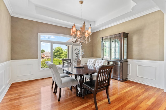 3702 E Dartmoor Ct, Springfield, MO 65802 - dining room with a raised ceiling, light wood-type flooring, a chandelier, wainscoting, and a decorative wall