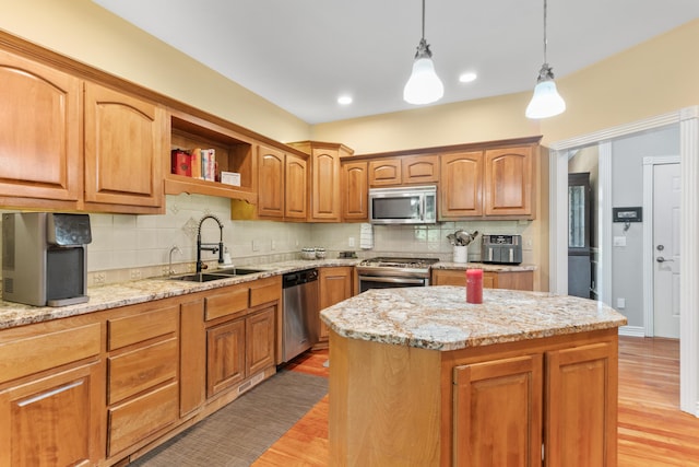 3702 E Dartmoor Ct, Springfield, MO 65802 - kitchen with appliances with stainless steel finishes, tasteful backsplash, hanging light fixtures, and light stone counters