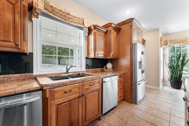 160 Brookside Ct, Branson, MO 65616 - kitchen with appliances with stainless steel finishes, backsplash, brown cabinetry, light tile patterned flooring, and recessed lighting