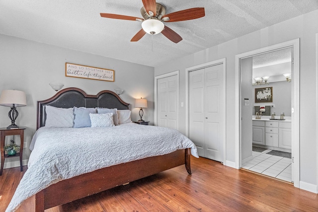 161 Avondale Dr Unit 1, Branson, MO 65616 - bedroom with light wood-type flooring, a textured ceiling, multiple closets, ensuite bathroom, and ceiling fan