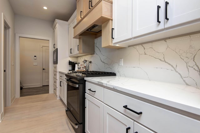3733 E Hutcheson Ave, Springfield, MO 65802 - kitchen with black appliances, custom exhaust hood, backsplash, light wood-type flooring, and white cabinetry