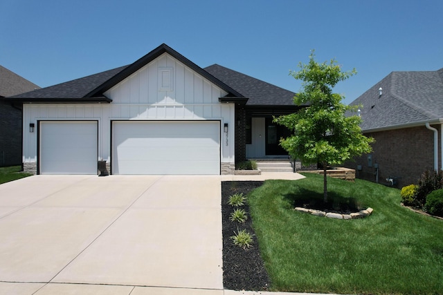 3733 E Hutcheson Ave, Springfield, MO 65802 - view of front of property with board and batten siding, a garage, a front lawn, concrete driveway, and roof with shingles