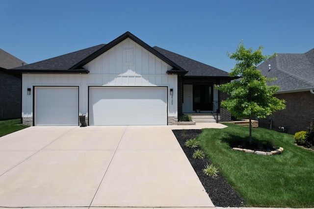 3733 E Hutcheson Ave, Springfield, MO 65802 - view of front facade featuring board and batten siding, a garage, concrete driveway, a front lawn, and roof with shingles