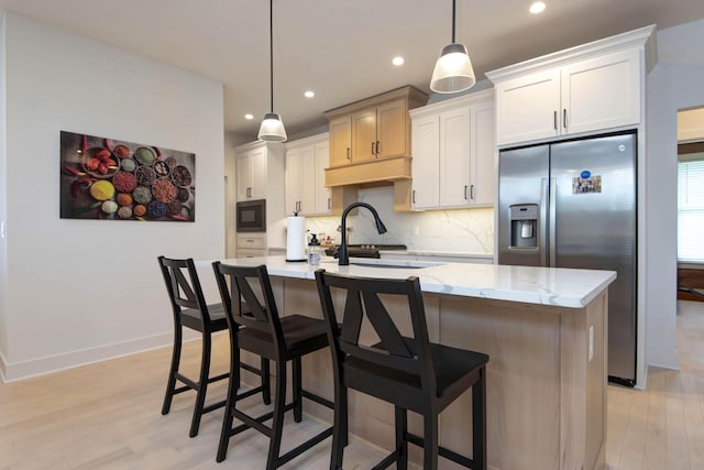 3733 E Hutcheson Ave, Springfield, MO 65802 - kitchen with stainless steel refrigerator with ice dispenser, black microwave, recessed lighting, light wood-style flooring, and tasteful backsplash