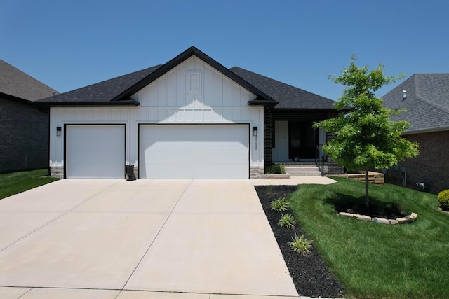 3733 E Hutcheson Ave, Springfield, MO 65802 - view of front of property with board and batten siding, an attached garage, driveway, a front lawn, and a shingled roof