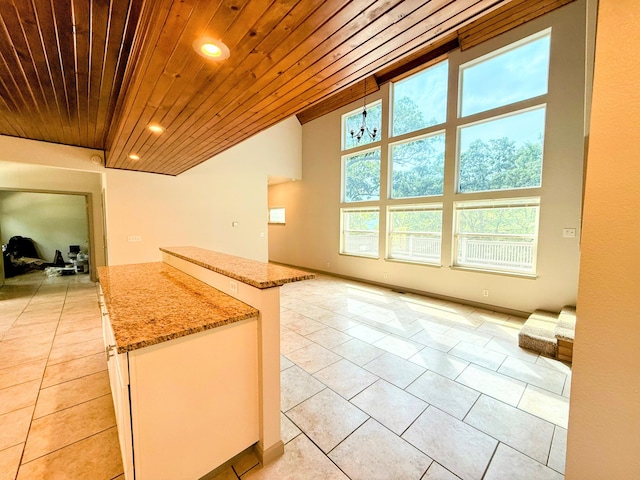 48 Galatians Ln, Reeds Spring, MO 65737 - kitchen with wooden ceiling, open floor plan, light tile patterned flooring, a kitchen island, and light stone counters