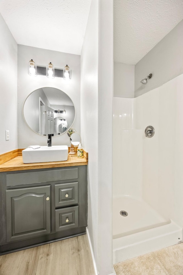 3936 S 77th Rd, Dunnegan, MO 65640 - full bathroom featuring wood finished floors, a shower, vanity, and a textured ceiling