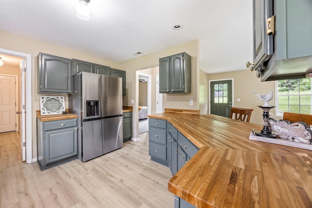 3936 S 77th Rd, Dunnegan, MO 65640 - kitchen featuring butcher block counters, stainless steel fridge with ice dispenser, light wood-type flooring, a peninsula, and gray cabinets