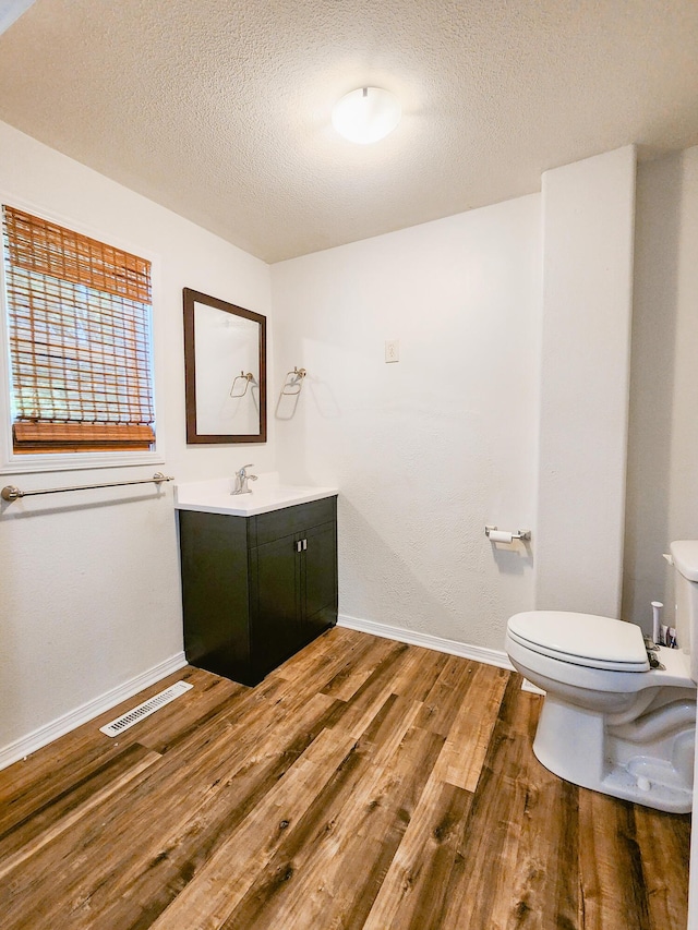 1305 N Main Ave, Springfield, MO 65802 - half bathroom with wood finished floors, vanity, and a textured ceiling
