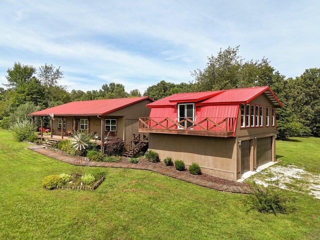 31 Mulberry Ln, Buffalo, MO 65622 - back of property with a metal roof, a yard, an attached garage, driveway, and stairs