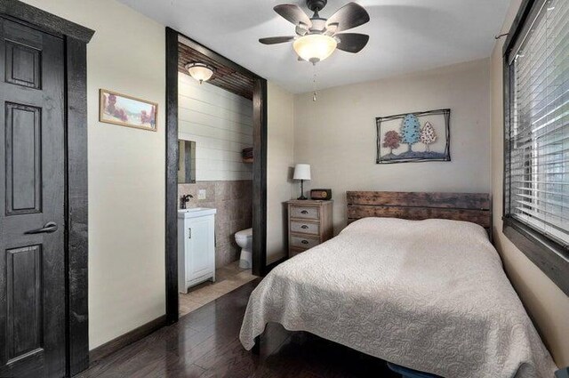 31 Mulberry Ln, Buffalo, MO 65622 - bedroom featuring wood finished floors, ensuite bathroom, tile walls, and a ceiling fan