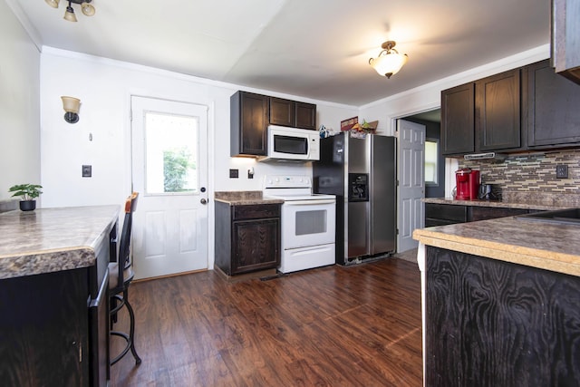 2718 E Blaine St, Springfield, MO 65803 - kitchen featuring white appliances, backsplash, dark wood finished floors, dark brown cabinets, and crown molding