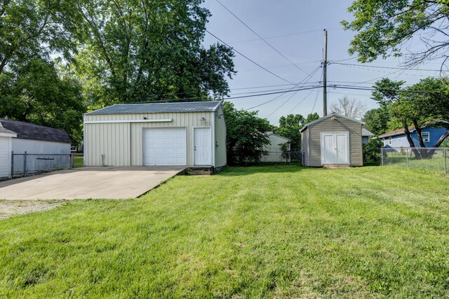 2718 E Blaine St, Springfield, MO 65803 - view of yard with a detached garage, concrete driveway, and a storage shed