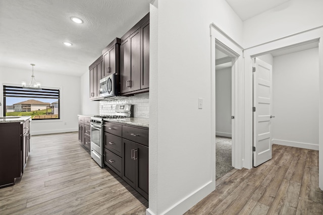 1305 W Ragweed Ct, Ozark, MO 65721 - kitchen with stainless steel appliances, light wood-style floors, backsplash, recessed lighting, and dark brown cabinetry