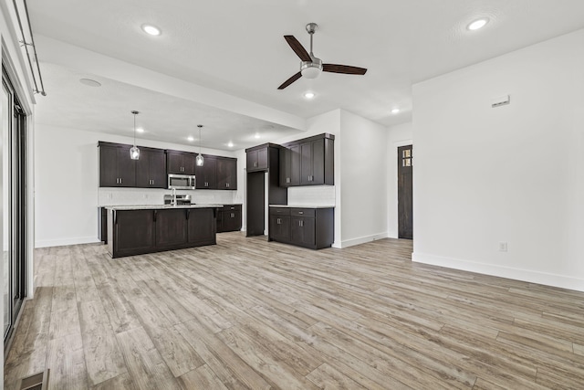 1305 W Ragweed Ct, Ozark, MO 65721 - kitchen featuring stainless steel microwave, ceiling fan, open floor plan, light wood-type flooring, and recessed lighting