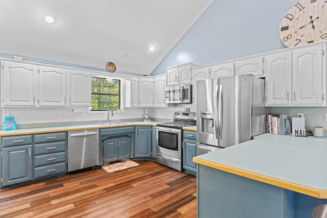 241 Sage Rd, Ozark, MO 65721 - kitchen featuring stainless steel appliances, white cabinetry, gray cabinetry, vaulted ceiling, and tasteful backsplash