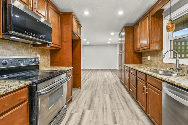 7047 W Lone Oak St, Springfield, MO 65803 - kitchen with stainless steel appliances, light stone counters, light wood-style floors, decorative backsplash, and brown cabinetry