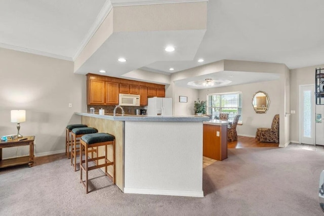 200 Glory Rd Unit B6, Branson, MO 65616 - kitchen with white appliances, a peninsula, light carpet, recessed lighting, and brown cabinetry