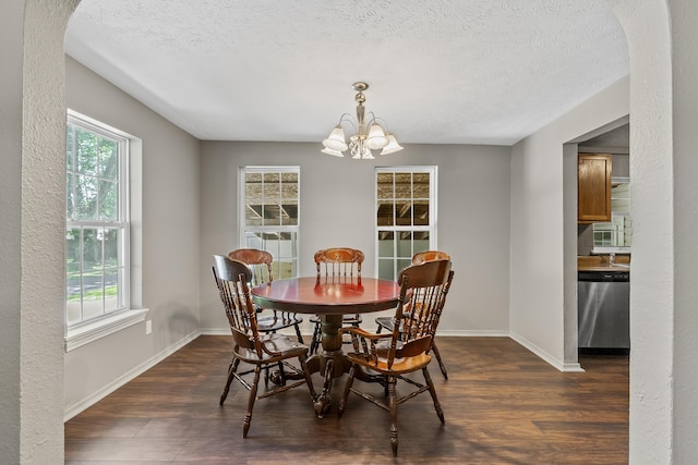 922 W Elm St, Springfield, MO 65806 - dining space with dark wood-style floors, a chandelier, arched walkways, and a textured ceiling