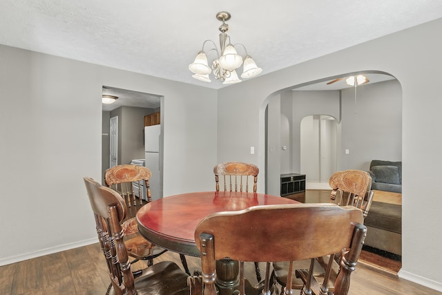 922 W Elm St, Springfield, MO 65806 - dining room featuring arched walkways, wood finished floors, and a chandelier