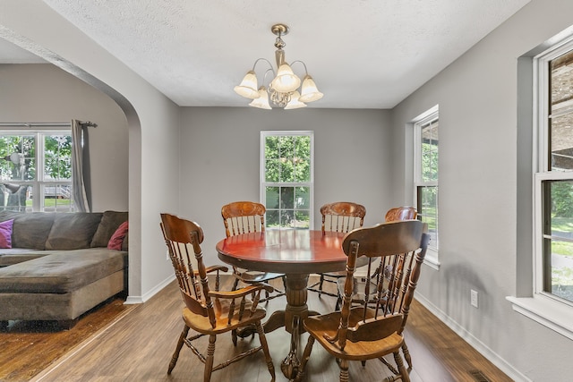 922 W Elm St, Springfield, MO 65806 - dining space featuring arched walkways, wood finished floors, and a chandelier