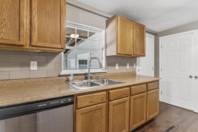 922 W Elm St, Springfield, MO 65806 - kitchen with dishwasher, dark wood finished floors, a textured ceiling, backsplash, and brown cabinets