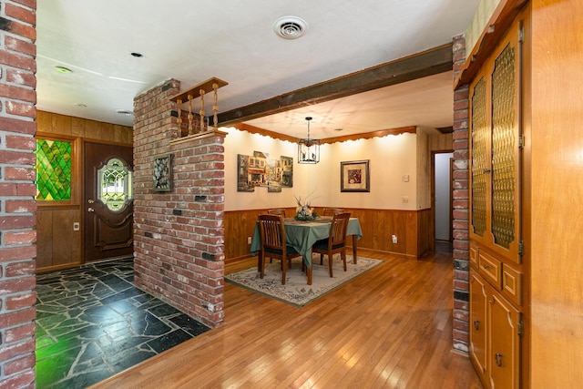 424 W Olive St, Bolivar, MO 65613 - dining space featuring wooden walls, wood-type flooring, a chandelier, and wainscoting