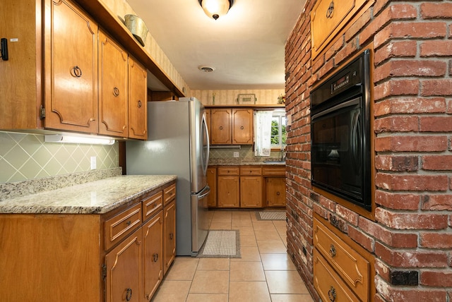 424 W Olive St, Bolivar, MO 65613 - kitchen featuring backsplash, brown cabinets, freestanding refrigerator, light tile patterned floors, and oven