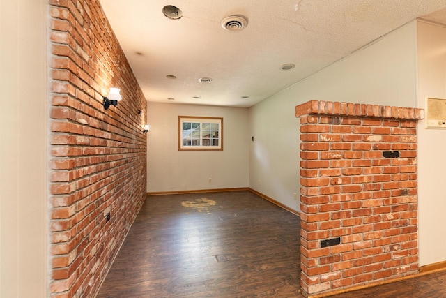 424 W Olive St, Bolivar, MO 65613 - spare room with wood finished floors, brick wall, and a textured ceiling