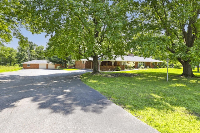 424 W Olive St, Bolivar, MO 65613 - view of front of house featuring driveway, a garage, a front lawn, brick siding, and a chimney
