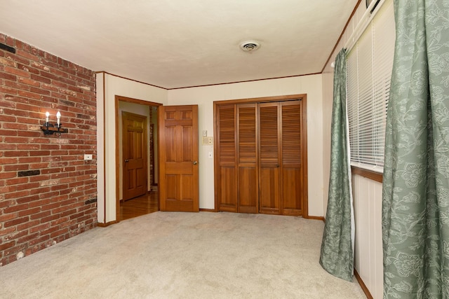 424 W Olive St, Bolivar, MO 65613 - unfurnished bedroom with a closet, carpet flooring, and brick wall