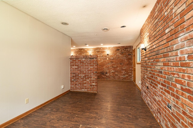 424 W Olive St, Bolivar, MO 65613 - empty room featuring wood finished floors, brick wall, and a textured ceiling