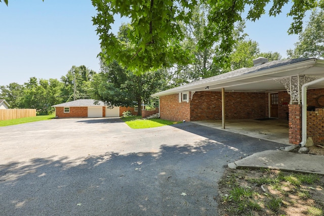 424 W Olive St, Bolivar, MO 65613 - view of property exterior featuring asphalt driveway, a carport, and brick siding