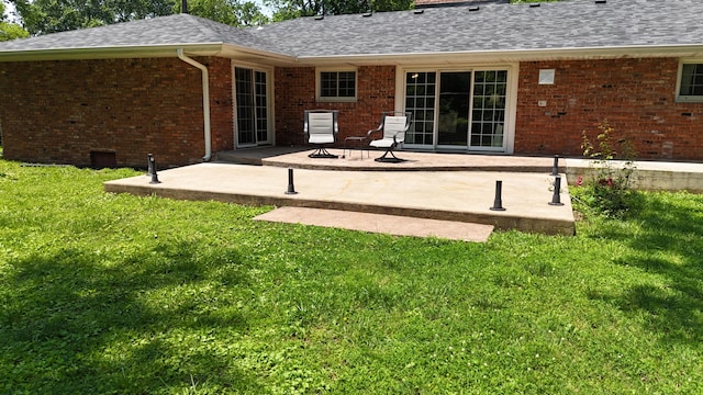 424 W Olive St, Bolivar, MO 65613 - rear view of property featuring brick siding, a patio area, a lawn, and roof with shingles