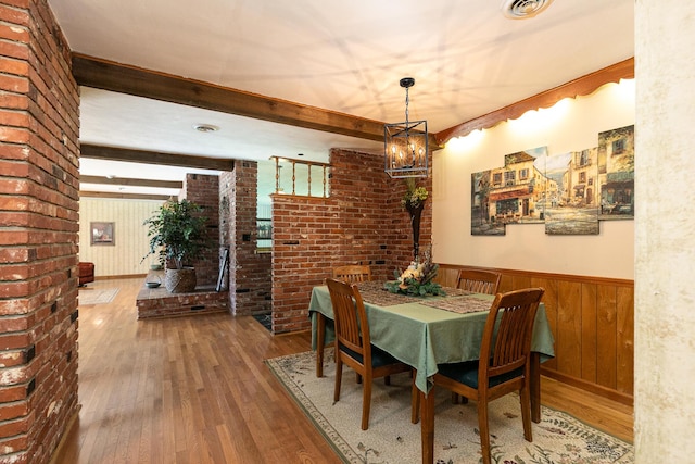 424 W Olive St, Bolivar, MO 65613 - dining space with hardwood / wood-style floors, wainscoting, a chandelier, wooden walls, and brick wall