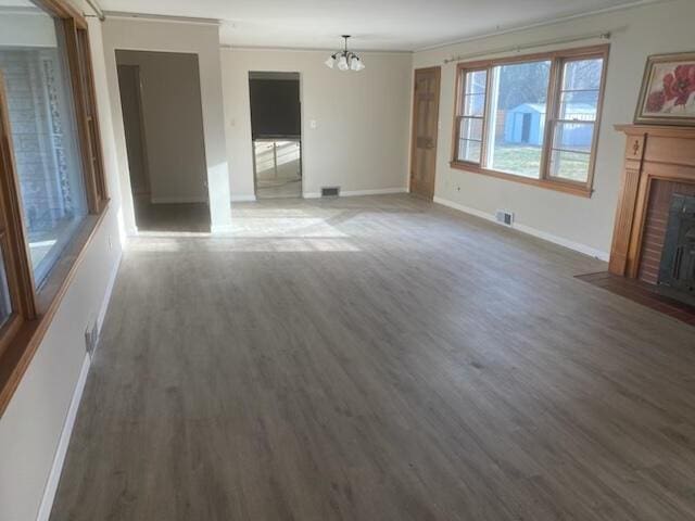 2166 S Lone Pine Ave, Springfield, MO 65804 - unfurnished living room featuring a chandelier, crown molding, wood finished floors, and a fireplace with flush hearth