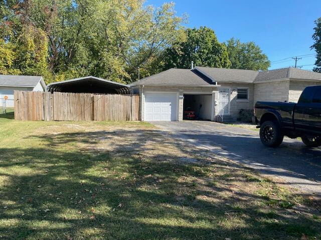 2166 S Lone Pine Ave, Springfield, MO 65804 - view of property exterior with asphalt driveway, a garage, and a carport