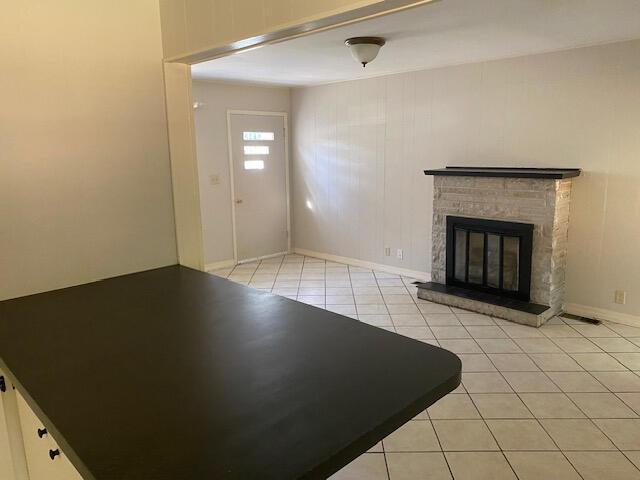 2166 S Lone Pine Ave, Springfield, MO 65804 - unfurnished living room featuring light tile patterned floors and a brick fireplace