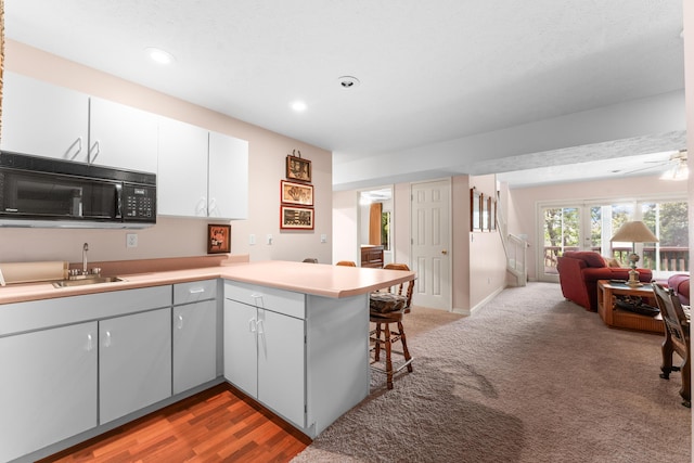 200 Eagle Pointe Dr, Branson, MO 65616 - kitchen featuring black microwave, a peninsula, open floor plan, a breakfast bar area, and recessed lighting