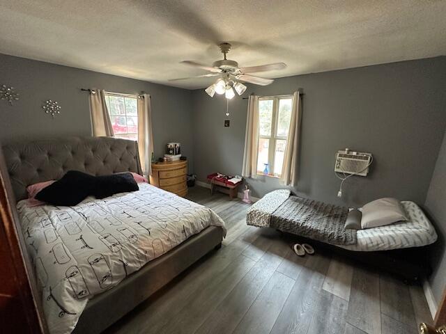 3200 Driftwood Rd, Merriam Woods, MO 65740 - bedroom featuring wood finished floors, a ceiling fan, and a wall mounted air conditioner