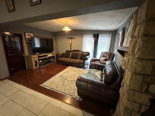 3200 Driftwood Rd, Merriam Woods, MO 65740 - living room featuring a fireplace, wood finished floors, and a textured ceiling