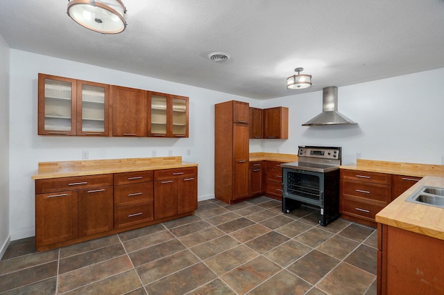 119 E Mill St, Republic, MO 65738 - kitchen featuring wall chimney range hood, range with electric cooktop, glass insert cabinets, brown cabinets, and wood counters