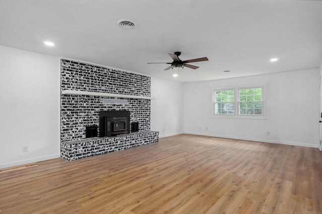 119 E Mill St, Republic, MO 65738 - unfurnished living room with a ceiling fan, wood finished floors, a wood stove, and recessed lighting