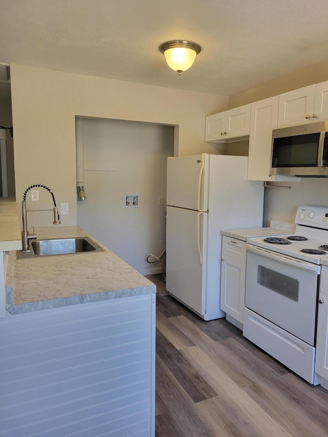 809 Elm Ave, Ava, MO 65608 - kitchen with white appliances, wood finished floors, white cabinetry, and light countertops